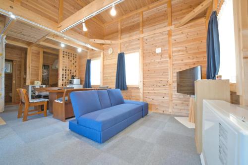 a living room with a blue chair and a television at LAKE TOYA Logde SIGRA in Lake Toya