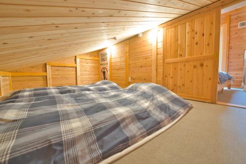 a bed in a room with wooden walls at LAKE TOYA Logde SIGRA in Lake Toya