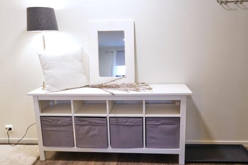 a white dressing table with a mirror on it at Victoriagården- Losji in Grimstad