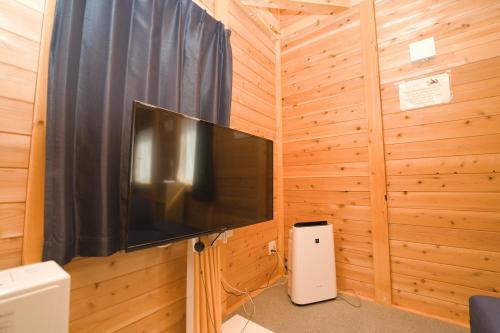 a television on a wooden wall in a room at LAKE TOYA Logde SIGRA in Lake Toya