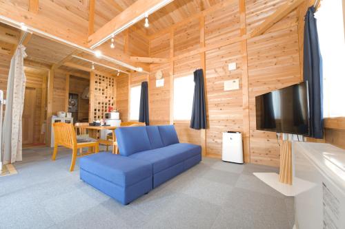 a living room with a blue couch and a television at LAKE TOYA Logde SIGRA in Lake Toya