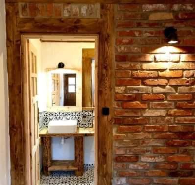 a bathroom with a sink and a brick wall at MotoMotel-Myczkowianka Sadyba in Myczkowce