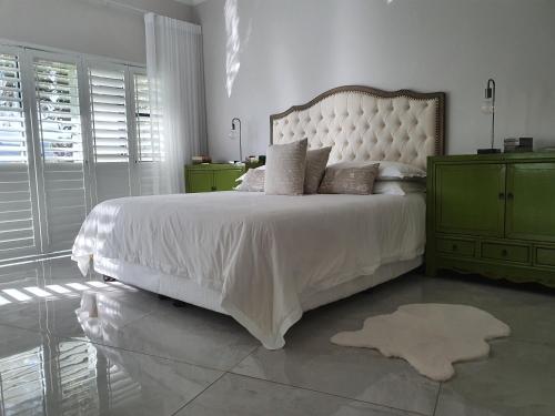 a bedroom with a white bed and a green dresser at Best of Both in Pecanwood Estate in Hartbeespoort