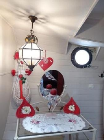 Cette chambre comprend un miroir et une table avec une lampe. dans l'établissement Bateau Mariance, à Ginestas