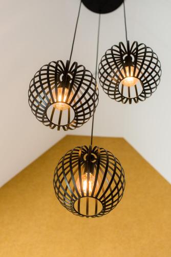 three metal lights hanging from a ceiling at Breeze Ameland in Hollum