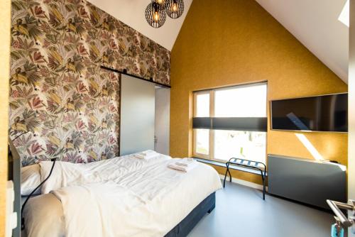 a bedroom with a large bed and a tv at Breeze Ameland in Hollum