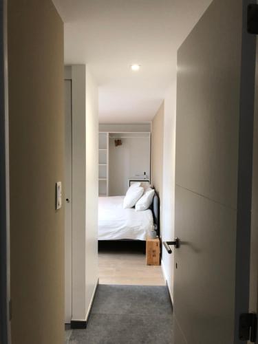 1 dormitorio con 1 cama y una puerta que conduce a una habitación en La casetta del Nonno, en Floreffe