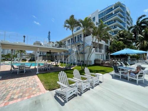 a patio with chairs and a pool and a building at Holiday Isle Yacht Club in Fort Lauderdale