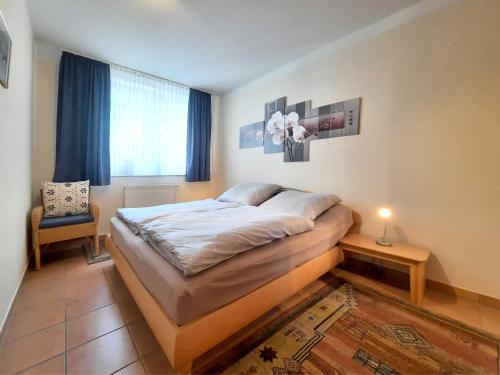ein Schlafzimmer mit einem Bett und einem Stuhl und einem Fenster in der Unterkunft Ferienwohnung Seejuwel Objekt ID 13833 in Seebad Kölpinsee