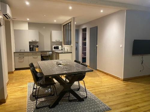 een woonkamer met een tafel en een keuken bij Appartement équipé au centre de Bletterans in Bletterans