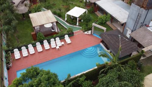 een uitzicht op een zwembad met stoelen en een huis bij Apart Hotel Las Violetas in Candelaria