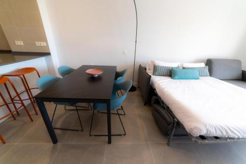 a small room with a bed and a table and chairs at Aqua Apartments Bellamar, Marbella in Marbella