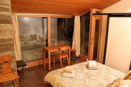 グリンデルワルトにあるChalet Morganeのベッド、テーブル、窓が備わる客室です。