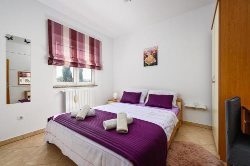 a bedroom with a bed with two towels on it at BOŽICA House with apartments in Murine