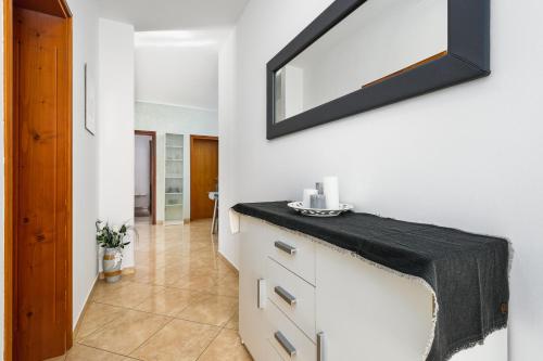Łazienka z czarnym blatem i lustrem na ścianie w obiekcie BOŽICA House with apartments w mieście Murine