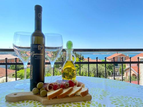 - une bouteille de vin, du fromage et des verres à vin sur une table dans l'établissement Apartments Stela, à Gornji Karin
