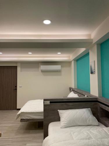 a bedroom with two beds and blue walls at 小島上island in Dongyin