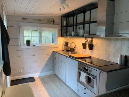 a kitchen with a sink and a stove at Mysigt gårdshus på vackra Stensö in Kalmar