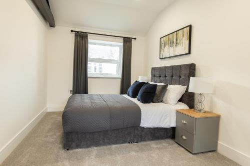 Un dormitorio con una cama grande y una ventana. en Coniston House near Bolton, Appleby-in-Westmorland by Guestz, en Kirkby Thore