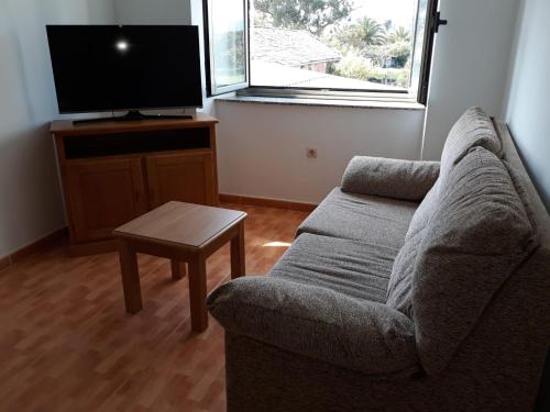 sala de estar con sofá y TV en Inmejorable para descanso, playa y montaña Ribadeo, en Ribadeo