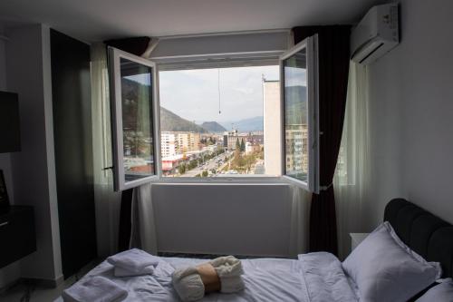 a bed in a bedroom with a large window at Apart Hotel Center in Piatra Neamţ