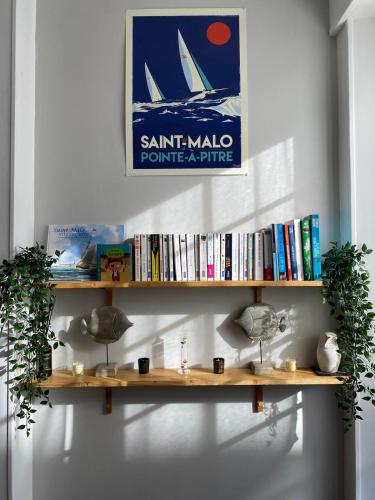 une étagère avec des livres et une pancarte sur un mur dans l'établissement Nice Apartment In Downtown And Near The Beach, à Saint-Malo
