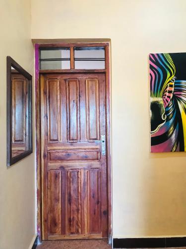 a wooden door in a room with a painting at Palm Tree Villa Nungwi in Nungwi