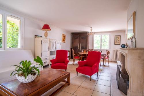 un salon avec des chaises rouges et une table dans l'établissement Welcome To The Nossi Bé Villa, à La Garde