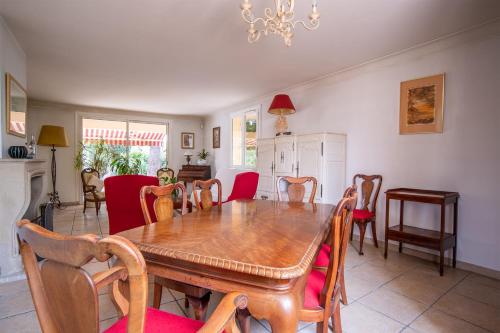 une salle à manger avec une table et des chaises en bois dans l'établissement Welcome To The Nossi Bé Villa, à La Garde