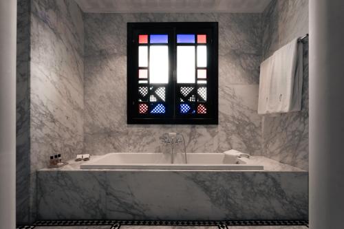 a bathroom with a tub and a stained glass window at Riad Fes - Relais & Châteaux in Fès
