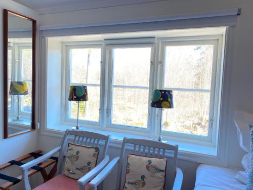 a room with two chairs and two windows at STF Kungsgården Långvind in Enånger