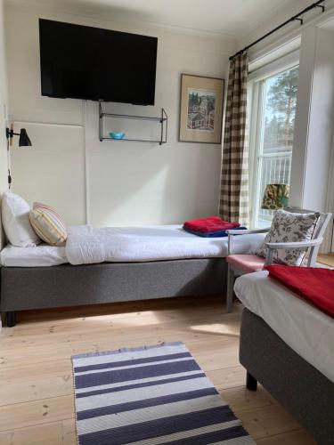 a bedroom with a bed and a tv on the wall at STF Kungsgården Långvind in Enånger