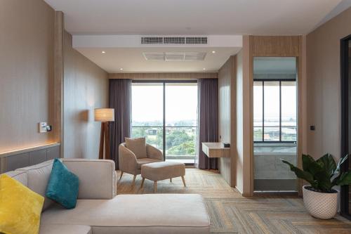 a living room with a couch and a chair at Laguna Grand Hotel & Spa Songkhla in Songkhla