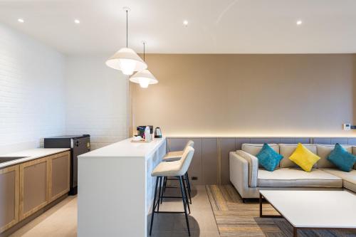 a kitchen and a living room with a couch at Laguna Grand Hotel & Spa Songkhla in Songkhla