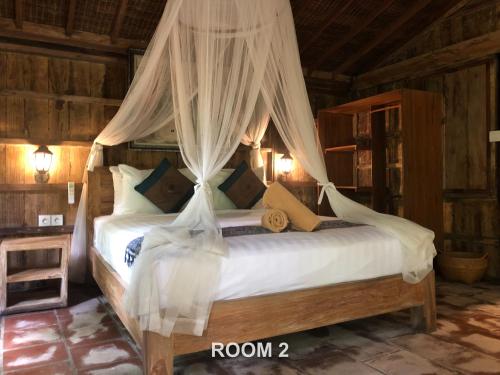 a bedroom with a bed with a canopy at Sweet Orange Pondok in Ubud
