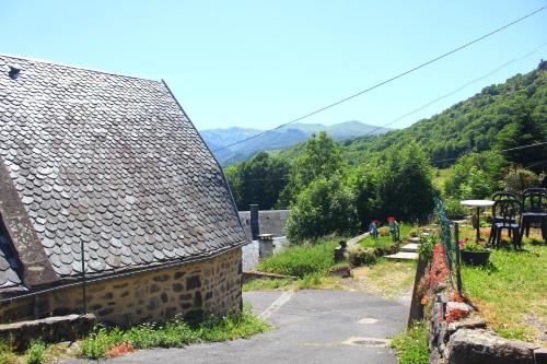 einen Blick auf ein Haus mit einem Berg im Hintergrund in der Unterkunft Maison de Varennes in Chambon-sur-Lac