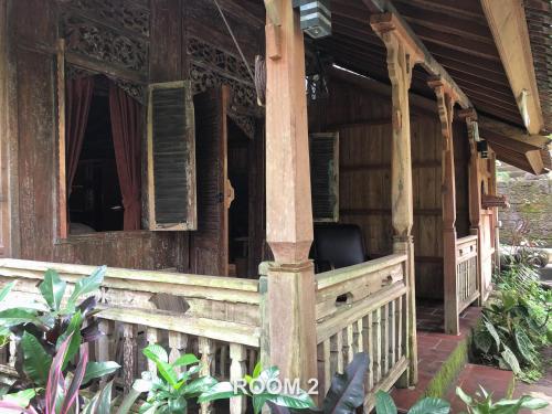 a porch of a house with a chair on it at Sweet Orange Pondok in Ubud
