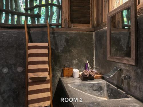 a bathroom with a sink and a wooden ladder at Sweet Orange Pondok in Ubud