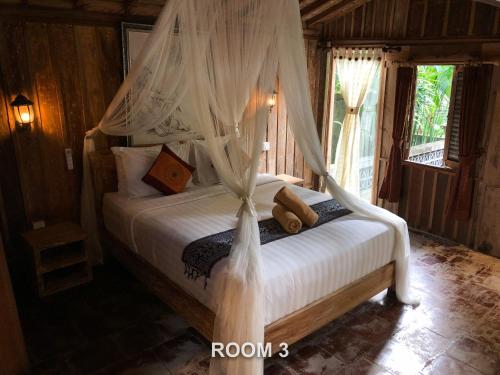 a bedroom with a bed with a canopy at Sweet Orange Pondok in Ubud