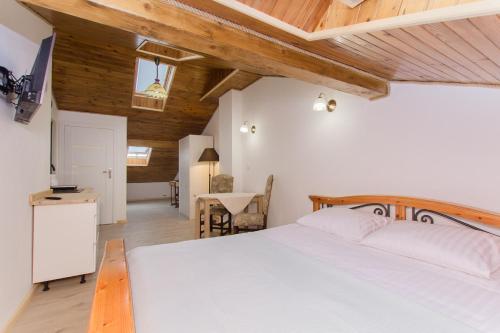 a bedroom with a white bed and wooden ceilings at Porto in Karwia