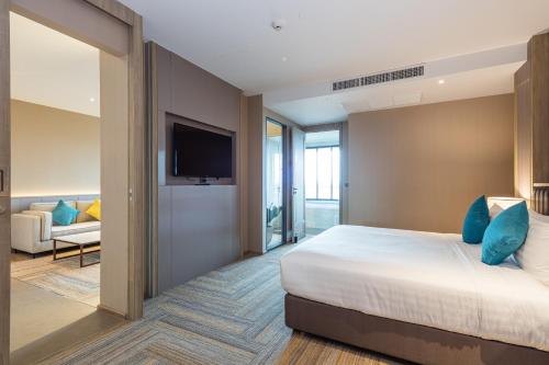 a hotel room with a bed and a tv at Laguna Grand Hotel & Spa Songkhla in Songkhla