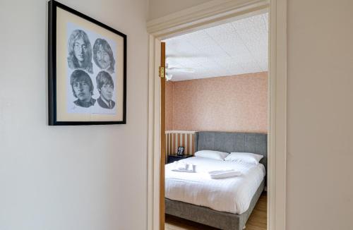 a bedroom with a bed and a picture on the wall at George Harrison's Former 3Bed Home in Liverpool in Speke