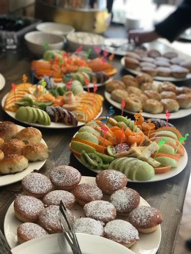 a table with plates of pastries and different types of food at Olive Ala-Archa Hotel & SPA in Verkhnyaya Alaarcha