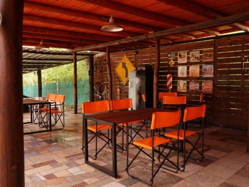 ビージャ・セラニタにあるCabañas Buen Diaのダイニングルーム(オレンジの椅子、テーブル付)