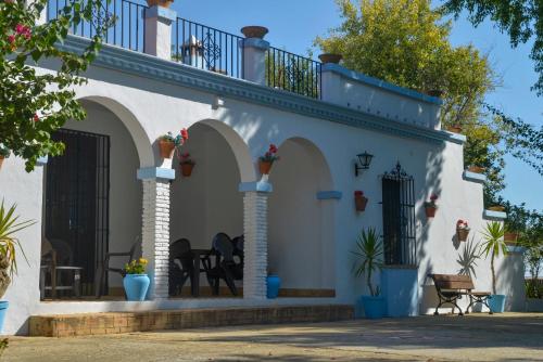 Cette maison blanche dispose d'arches et d'un balcon. dans l'établissement La Casa del Valle . Descansar junto a Doñana en plena naturaleza., à Manzanilla