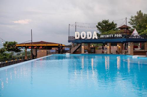 Bukit Indah Doda Hotel & Resorts في بالو: مسبح ازرق كبير امام مبنى