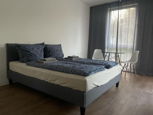 a bedroom with a bed with two chairs and a window at Appartements in der Kornstraße in Bremen