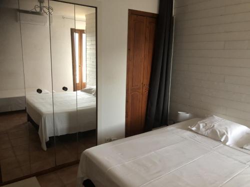 - une chambre avec 2 lits et un miroir dans l'établissement IN'D'NOI, à Ajaccio