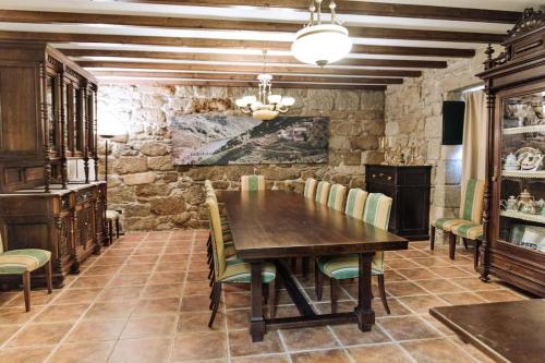 een eetkamer met een houten tafel en stoelen bij Casa Dos Gaios in Chantada
