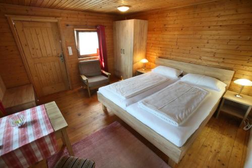 a bedroom with a large bed in a wooden cabin at Kellerstöckl Knusperhäuschen in Eltendorf